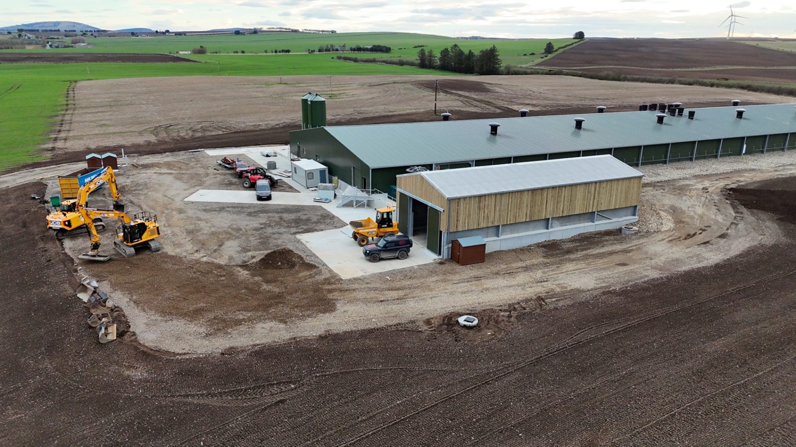 Aerial view of the poultry development showing the long green-roofed building and surrounding site works