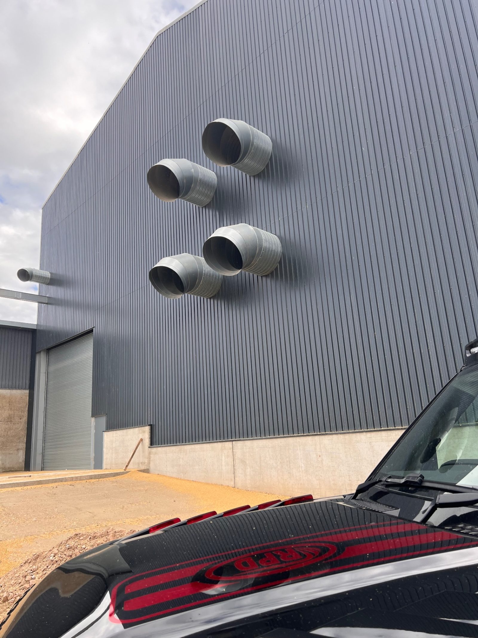 Silver ventilation ducts on the dark clad exterior of the grain storage building