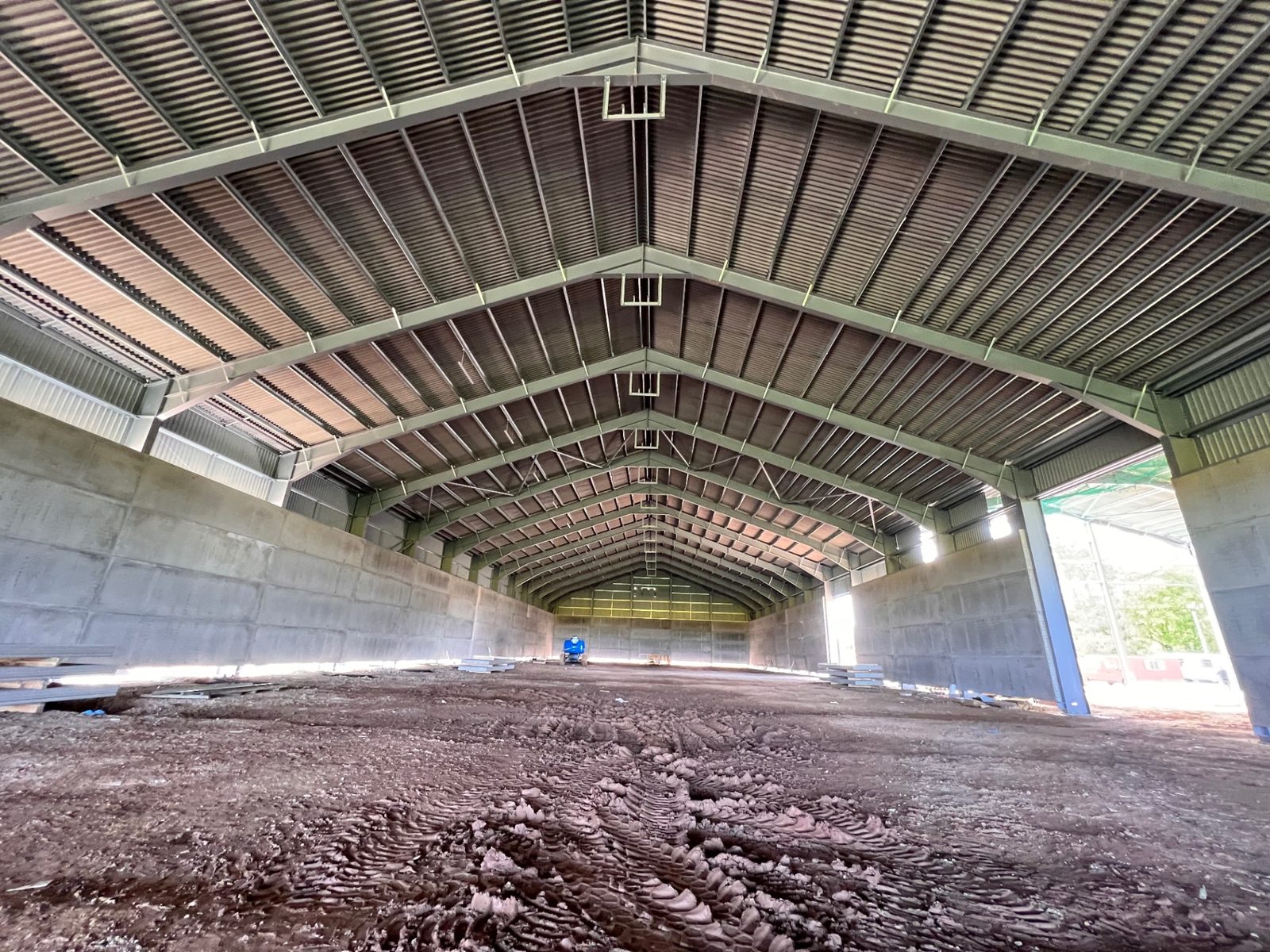 Interior of the grain store showing repeated roof frames above the concrete walls