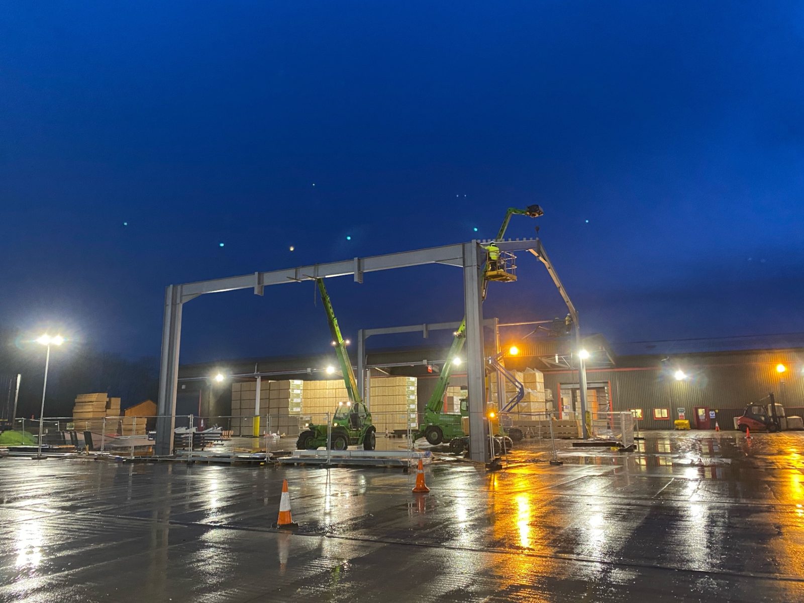 Steel frame erection at night under site lighting on the Highlands development