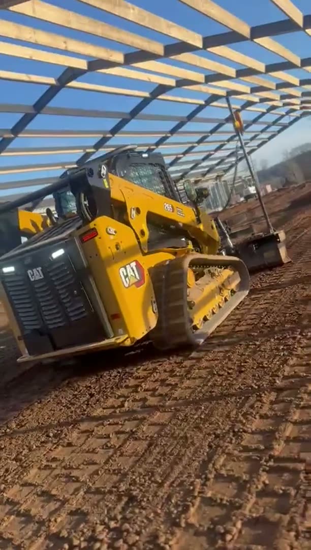 RPD CAT tracked loader fitted with the Trimble Earthworks system, grading a floor to level inside a steel-framed building