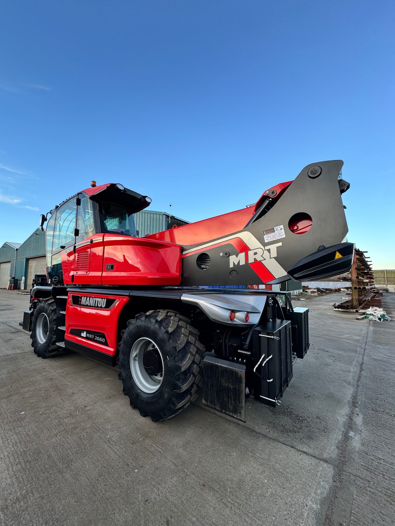 RPD Manitou MRT 2660 rotating telehandler at the yard beside stacked steel